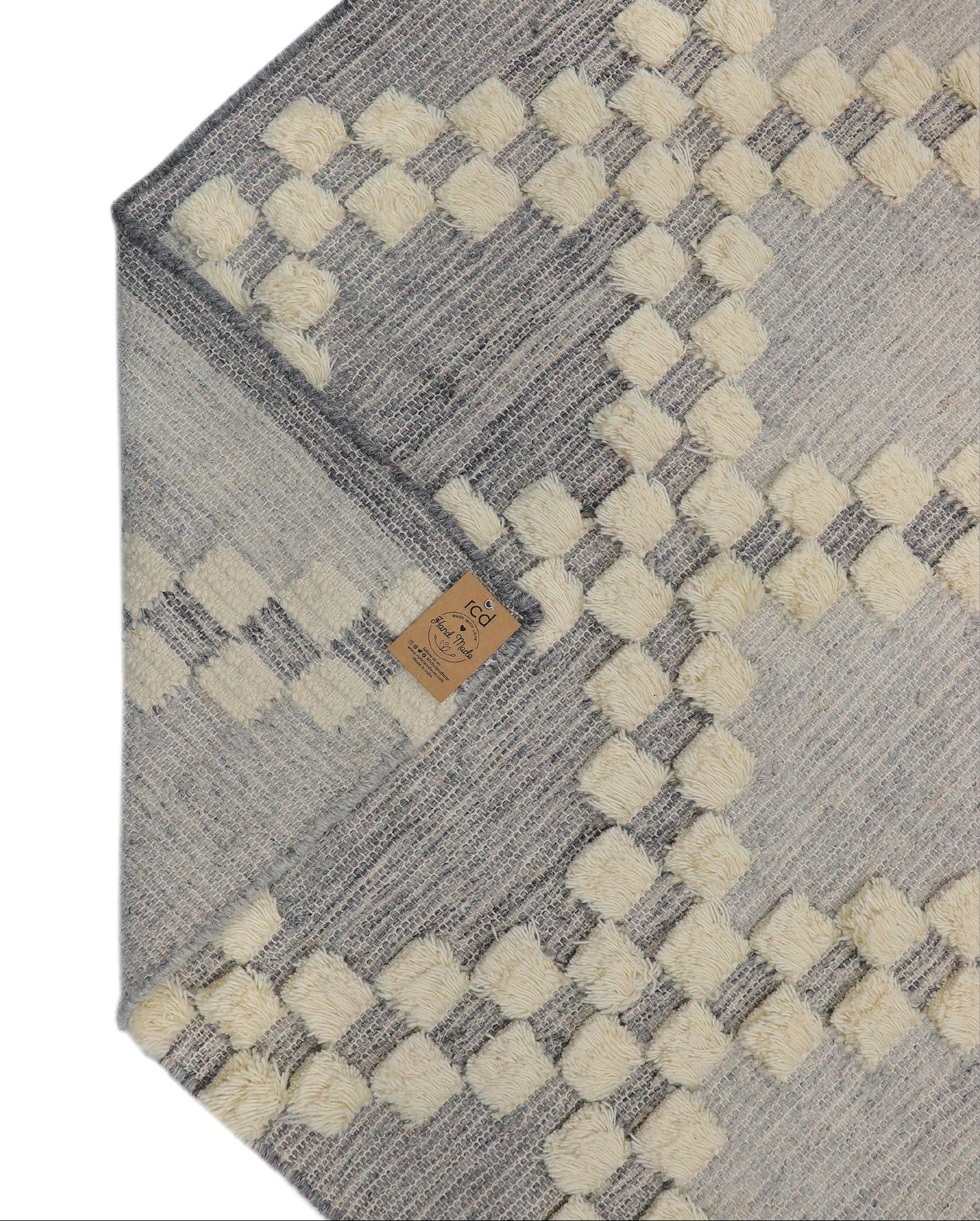 Gray and beige patterned rug with a rich class decor brand tag on a light gray background