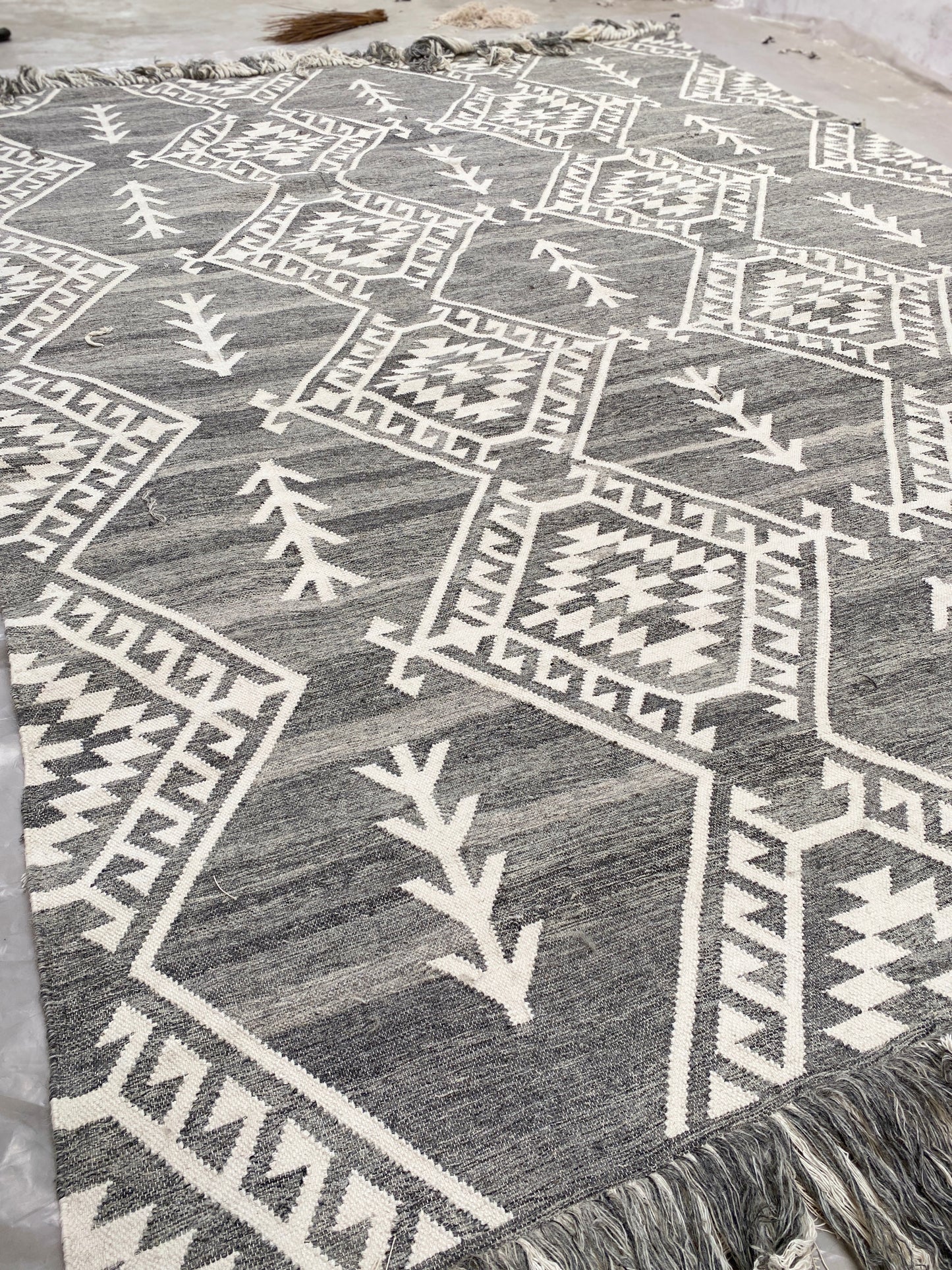 Handwoven Moroccan wool rug featuring intricate geometric patterns in neutral gray and ivory tones. This bohemian tribal area rug adds warmth, texture, and artisanal charm to any modern or rustic interior. Ethically crafted with premium materials for durability and style.