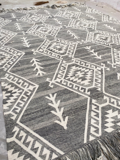 Handwoven Moroccan wool rug featuring intricate geometric patterns in neutral gray and ivory tones. This bohemian tribal area rug adds warmth, texture, and artisanal charm to any modern or rustic interior. Ethically crafted with premium materials for durability and style.
