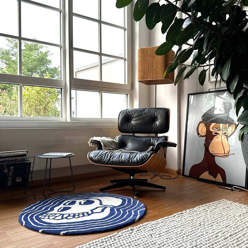 A gorgeous photo os a sitting are wth luxury leather recliner with a bored ape smoking in a potriat and a round blue skul rug handcrafter in wool by handtufting layed on the floor making the whole set up bespoke and amazing