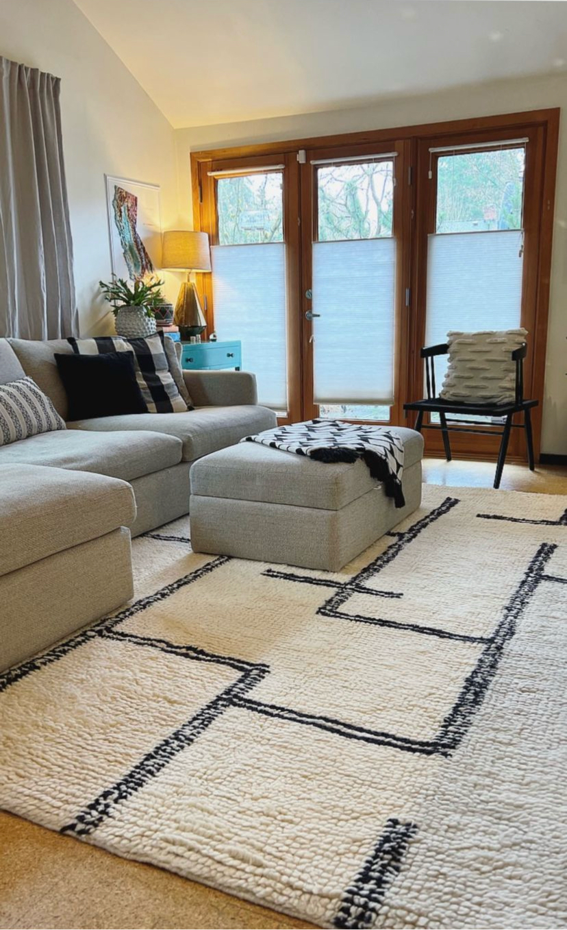 Beautiful living room with grey sofas with large windows and large 8x10 woollen textured rug in soft merino wool giving the whole room a very cozy vibes.
