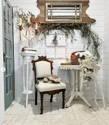 White decor setting with a chair flowers and a bespoke hand trimmed cotton tufted washable rug with farmhouse decor.