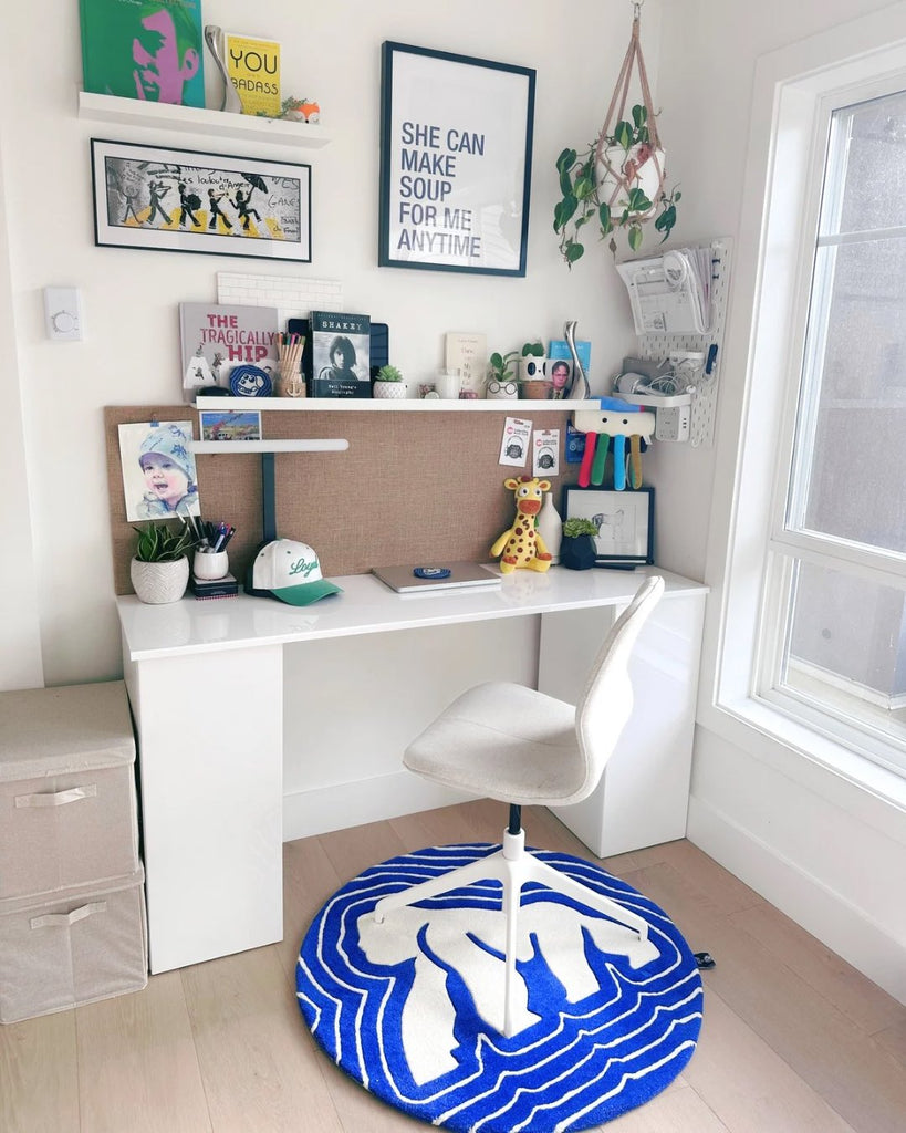 A custom made round ape hand tufted rug in blue and white in pure new zealand wool in a office setting. 