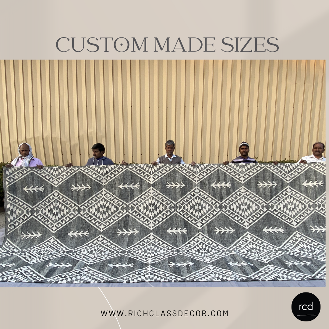 Custom-sized handcrafted kilim rug with intricate geometric patterns, held by skilled artisans. Ethically made using sustainable materials, this bohemian-style rug from Rich Class Decor is perfect for luxury home decor and interior design. Available in bespoke dimensions to suit any space.