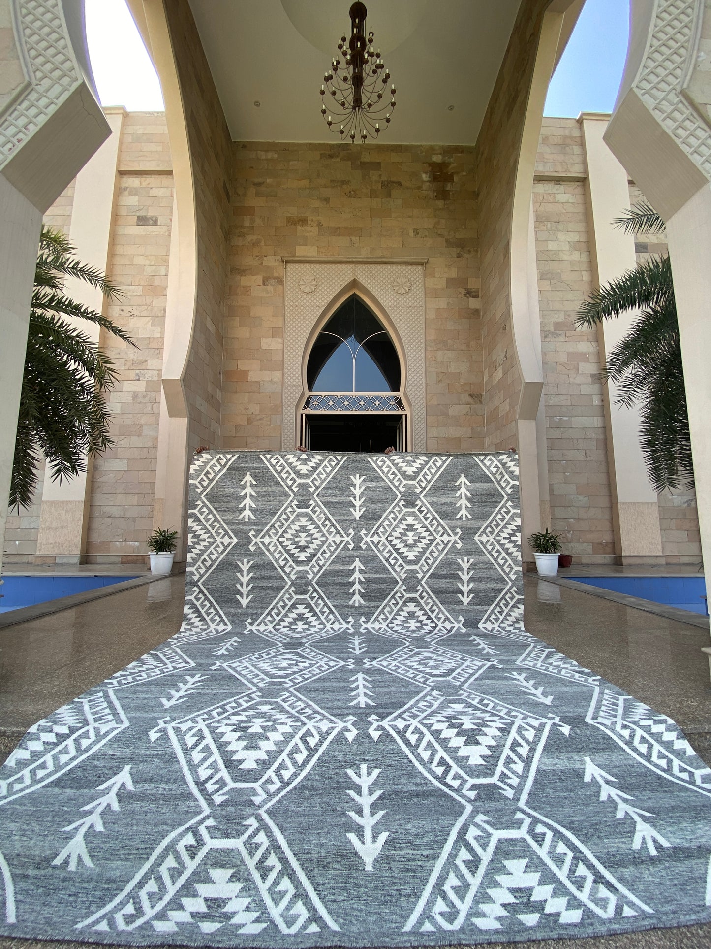 Handwoven black and white geometric wool rug with tribal patterns displayed in a luxury architectural setting. Perfect for modern bohemian home decor, living rooms, and designer interiors.