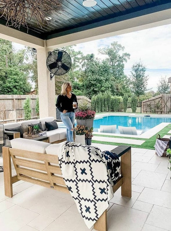 Faith Organic Cotton Throw Blanket – Luxurious 100% organic cotton black and white geometric throw, draped over a wooden outdoor bench in a stylish poolside patio. Soft, breathable, and ethically made, perfect for modern, boho, or farmhouse décor.