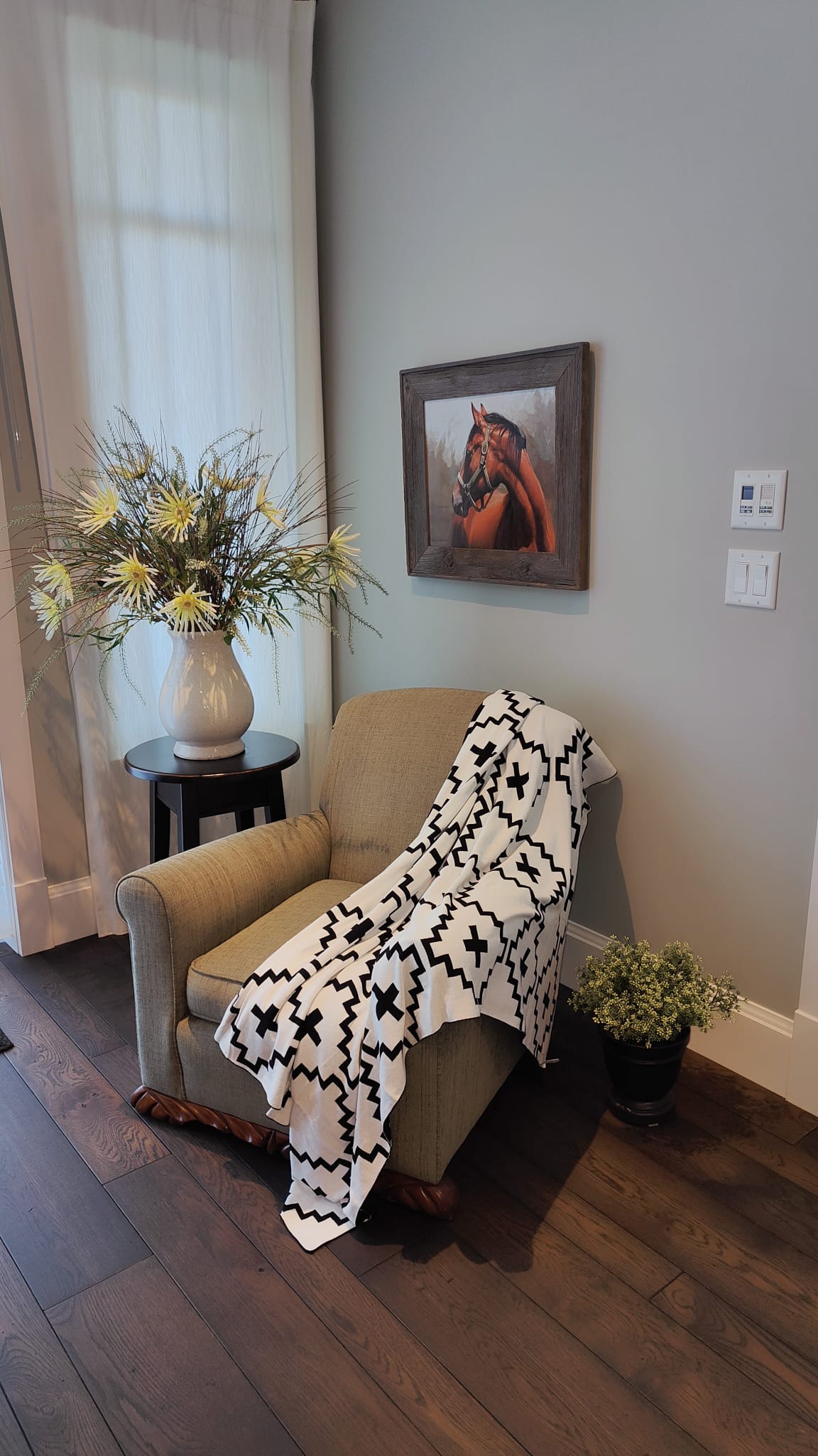 Faith Organic Cotton Throw Blanket with Free Matching Pillow – Soft black and white geometric patterned throw draped over a cozy armchair. Made from 100% organic cotton, perfect for modern, farmhouse, and boho-style home décor. Limited-time offer: Free matching pillow included!