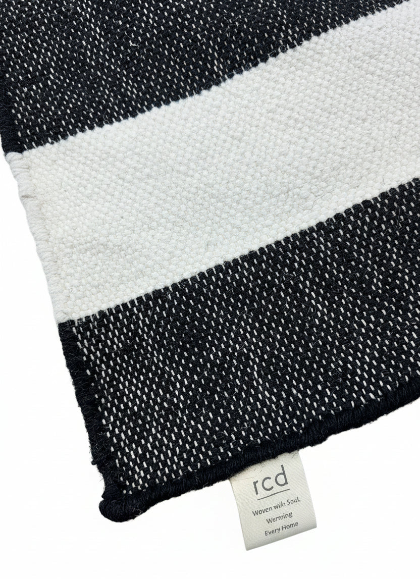 Black and white striped fabric with a brand label on a wooden surface