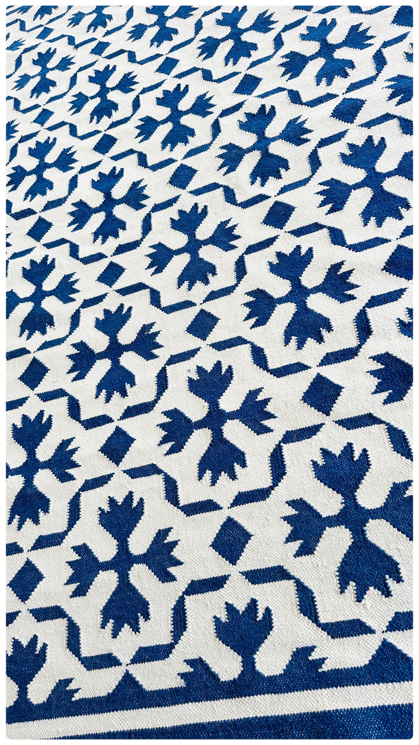 close up of jaipur intricate flatweave rug in blue & white