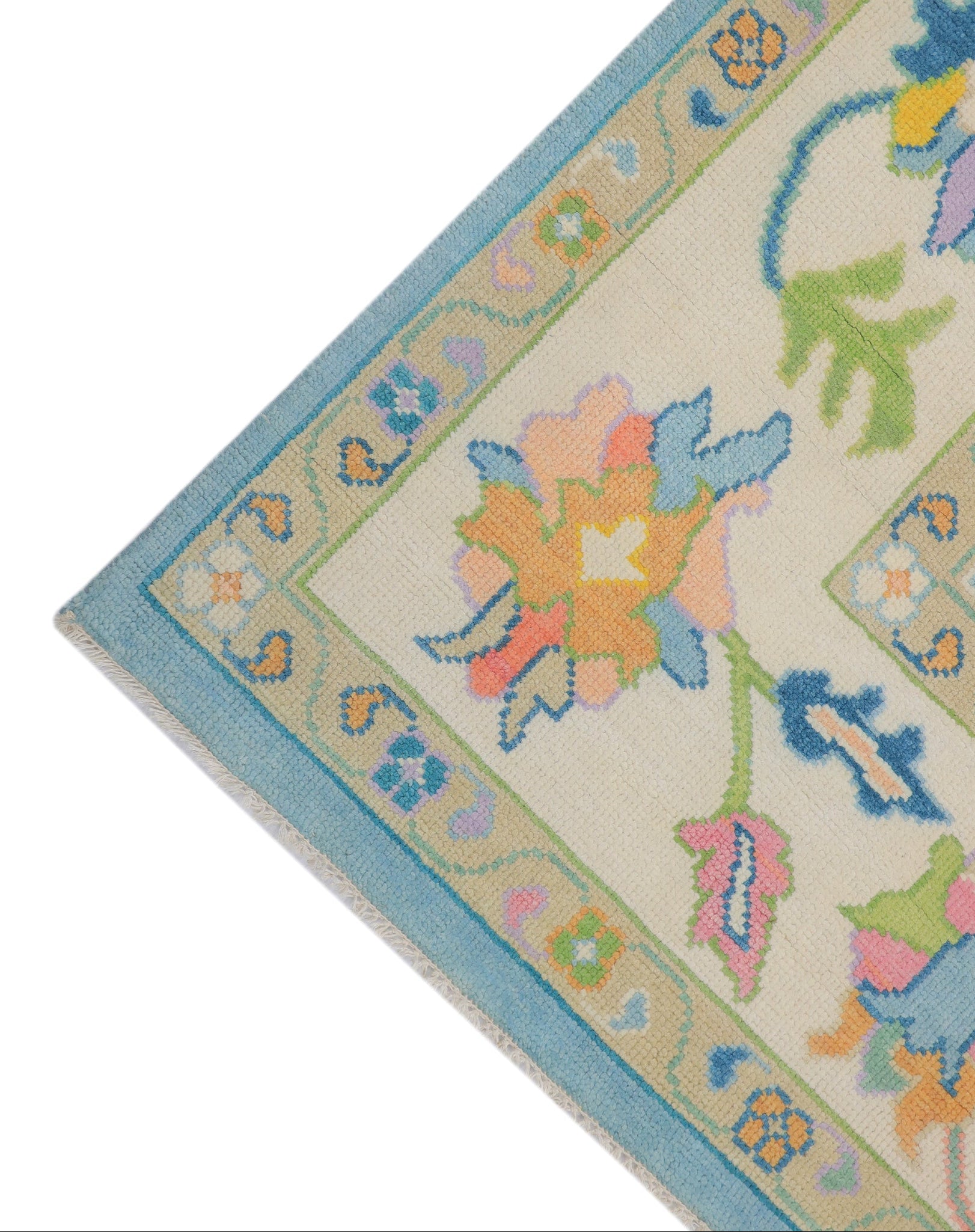lose-up of hand-knotted Oushak sky blue wool pile showing natural dye colour depth and botanical pattern detail