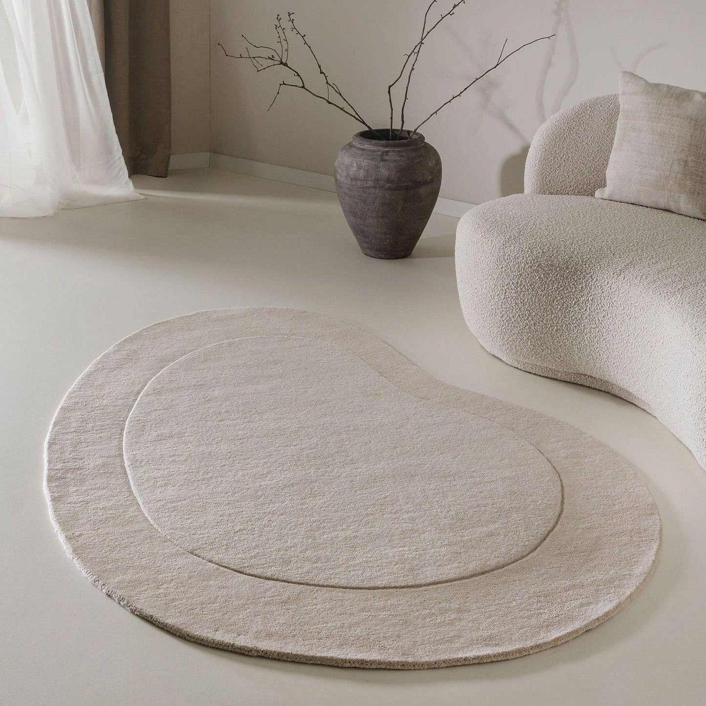 hand-tufted minimalist bean-shaped area rug in neutral tones beige