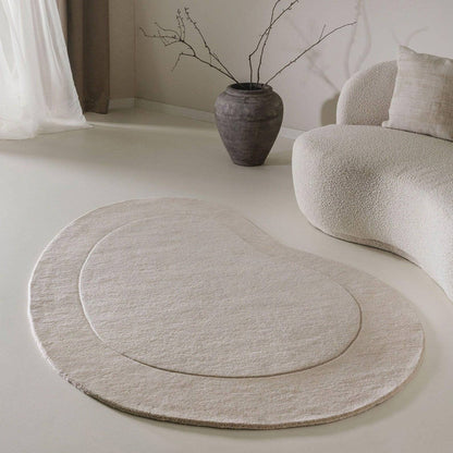 hand-tufted minimalist bean-shaped area rug in neutral tones beige