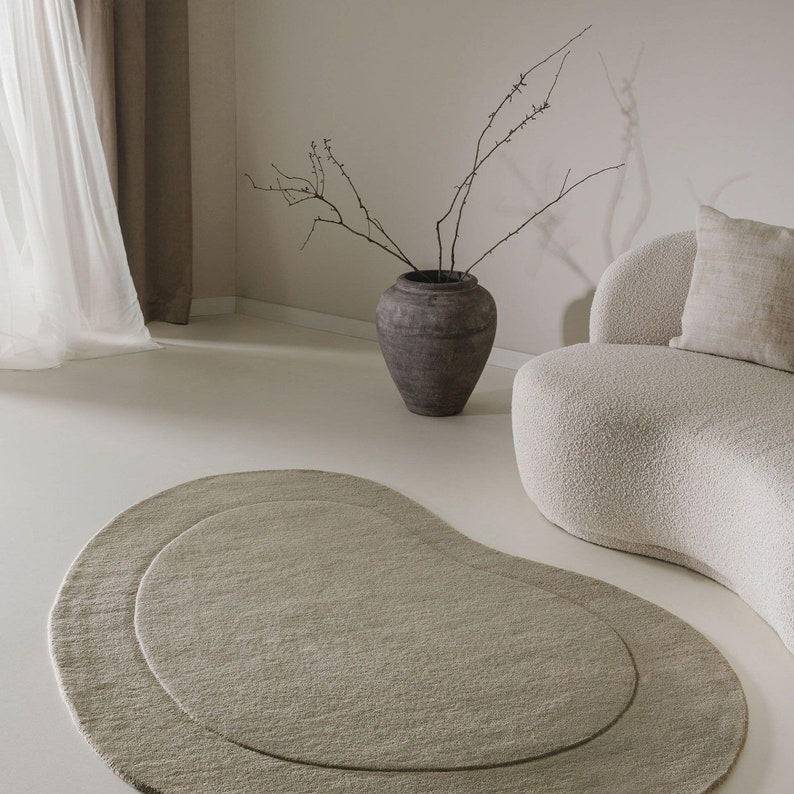 Sage green hand-tufted minimalist bean-shaped area rug in sage green tones
