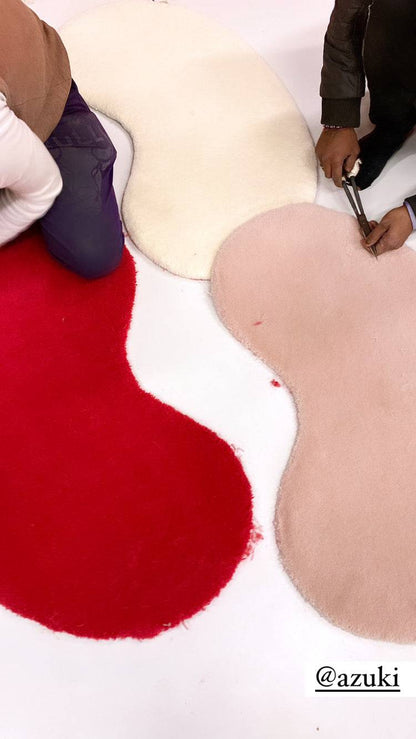 artisans working on custom bean shape rugs on bespoke rugs